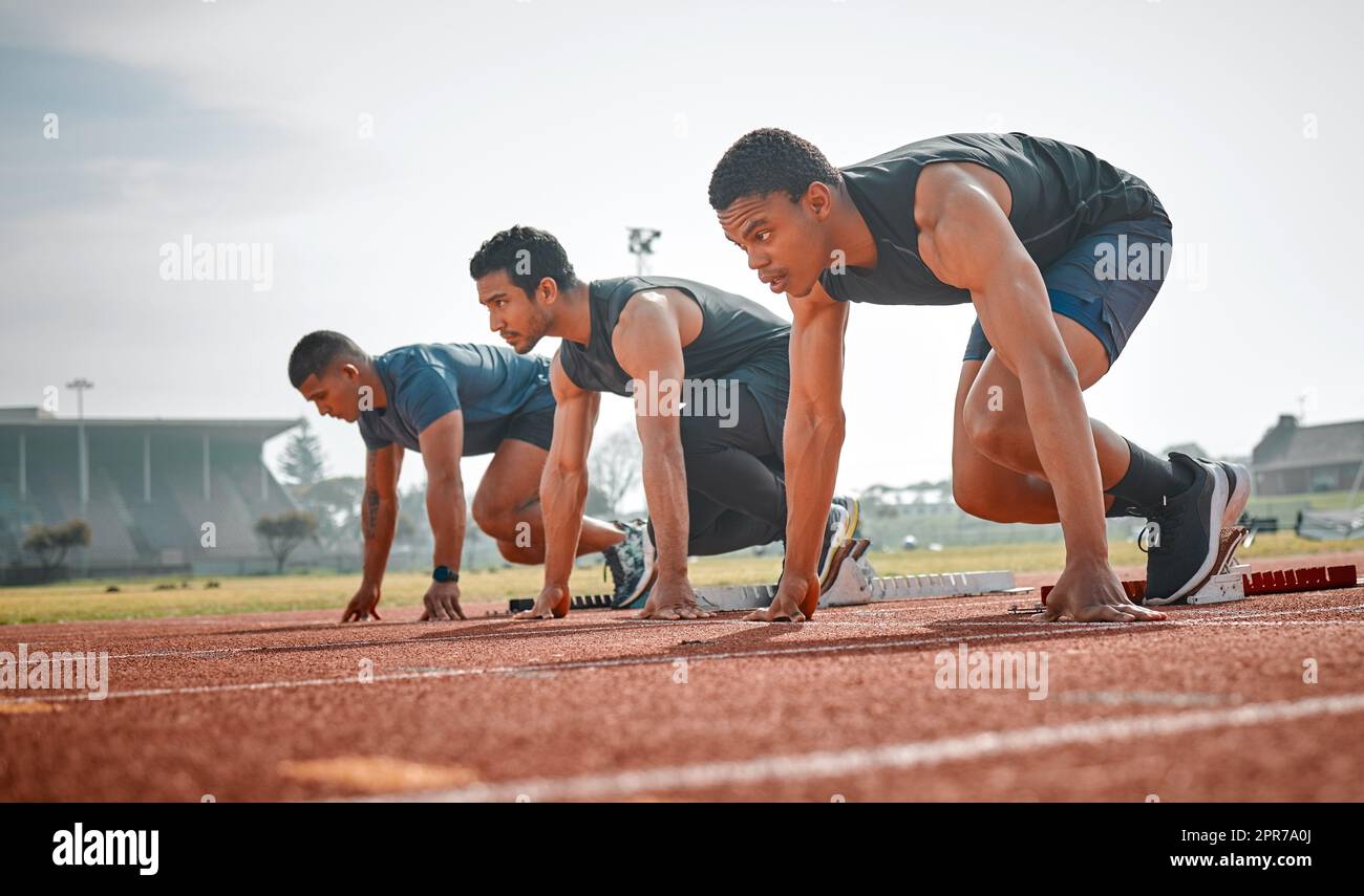 Take your mark. Full length shot of three handsome young male athletes