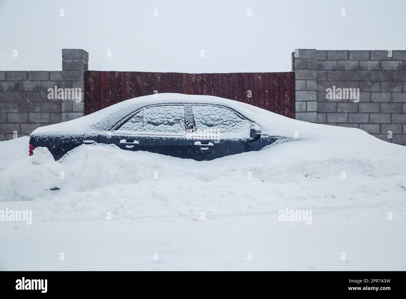 car parked near the fence is completely covered with snow Stock Photo ...