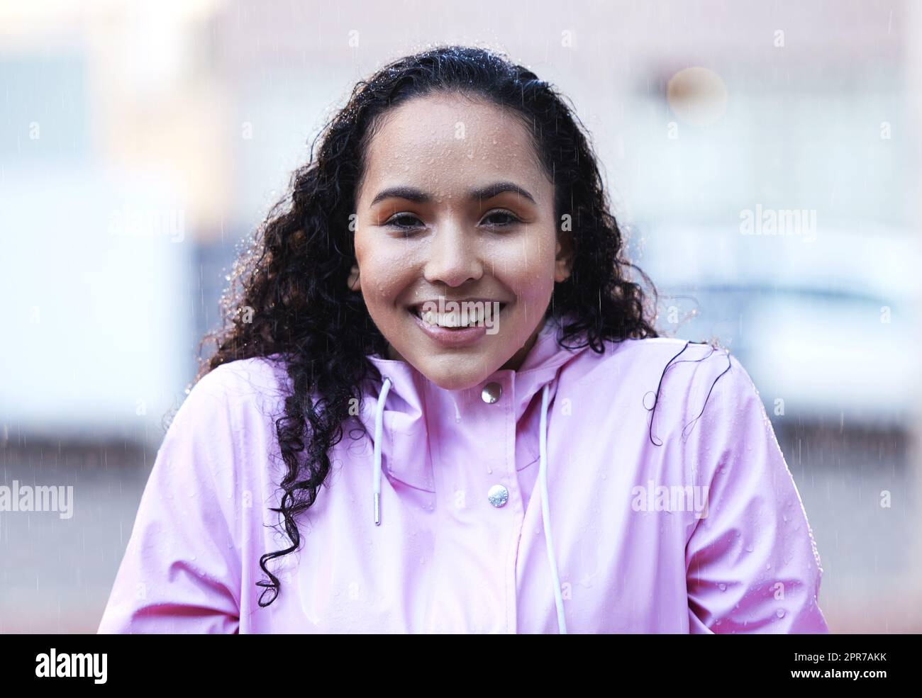 Rain wont stop her from getting out. a young woman standing in the rain