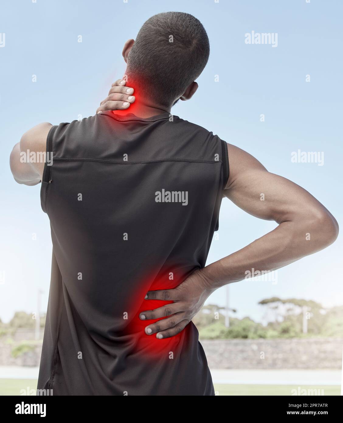 Injured and sore male runner suffering from sudden ache in his neck and back. Muscle strain or injury after a routine workout outdoors. Young sportsman struggling with unbearable pain during practice Stock Photo