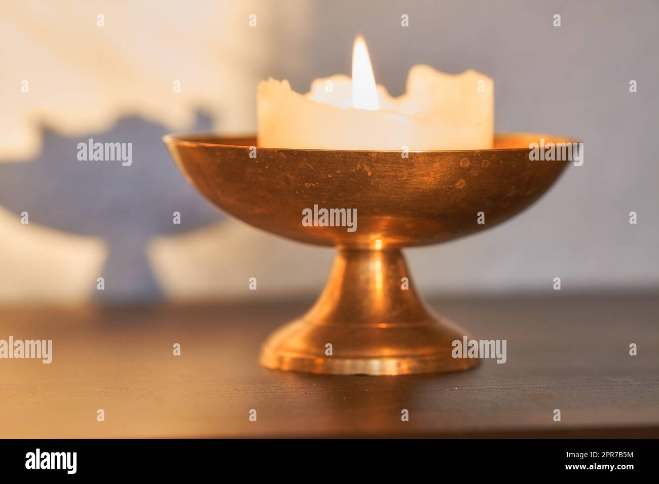 Elegant and decorative lit candle on a table at home. Beautiful house decorations used for aroma