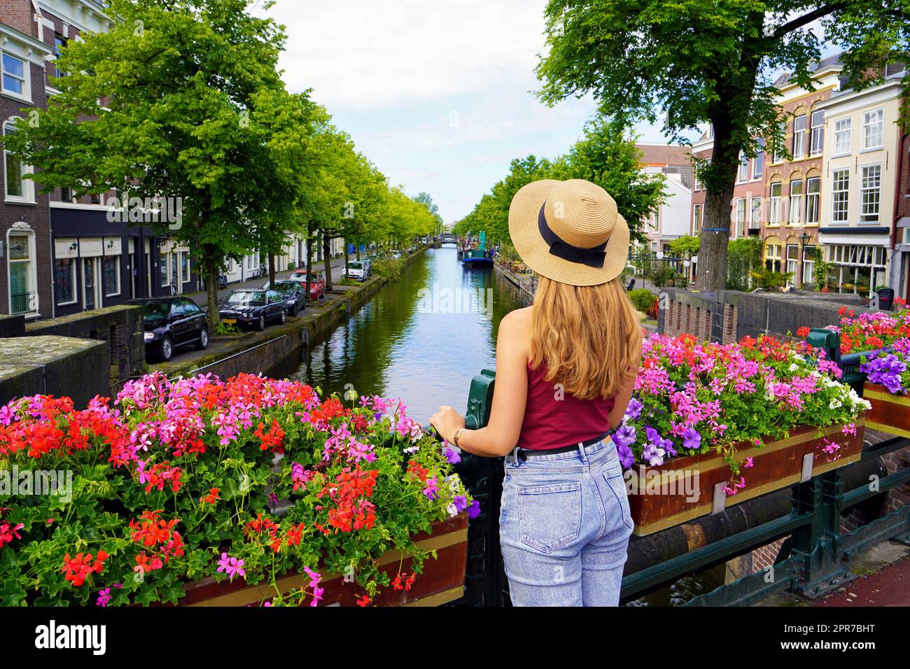 Tourism in Holland. Back view of beautiful fashion girl between flower pots in The Hague, Netherlands. Stock Photo