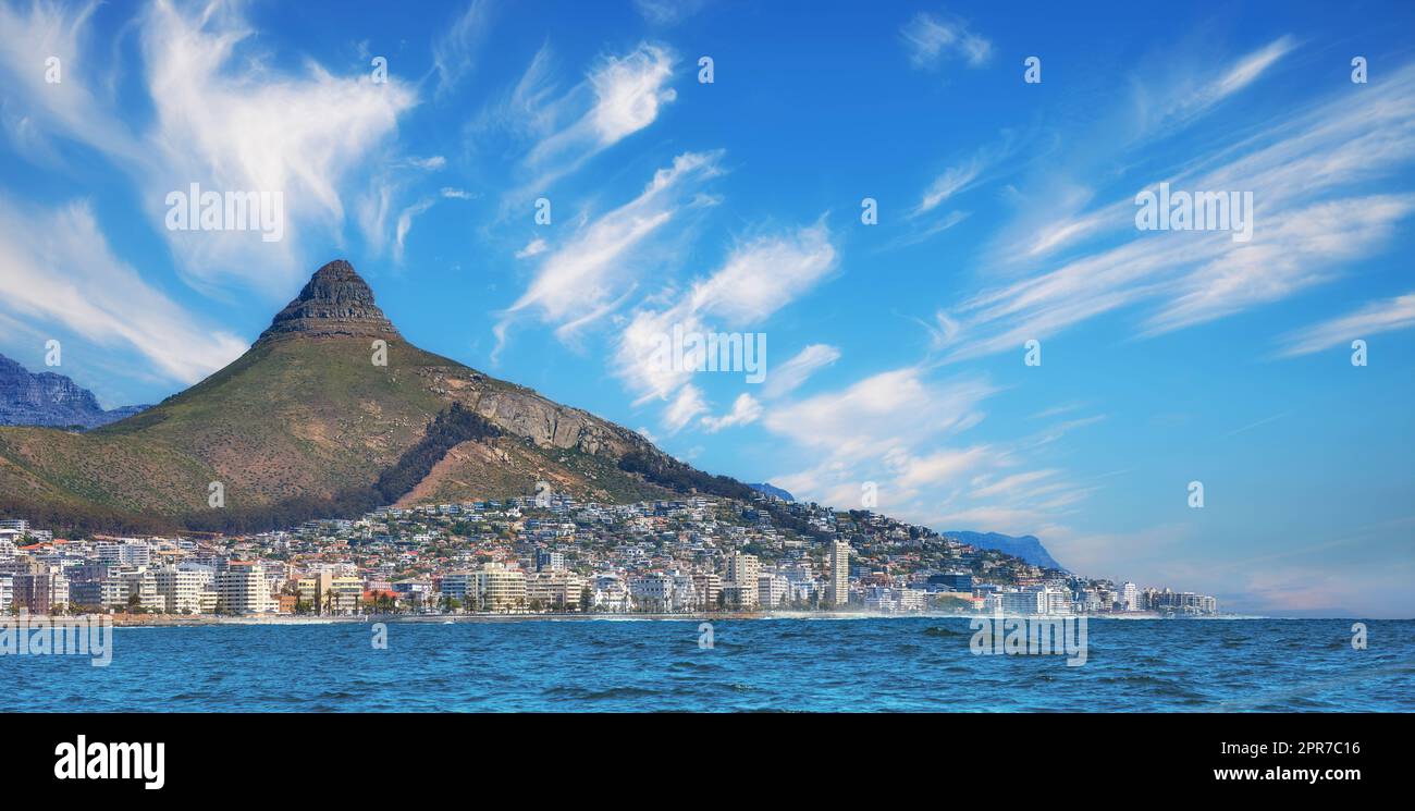 Copy space, panorama seascape with clouds, blue sky, hotels, and apartment buildings in Sea Point, Cape Town, South Africa. Lions head mountain overlooking the beautiful blue ocean peninsula Stock Photo