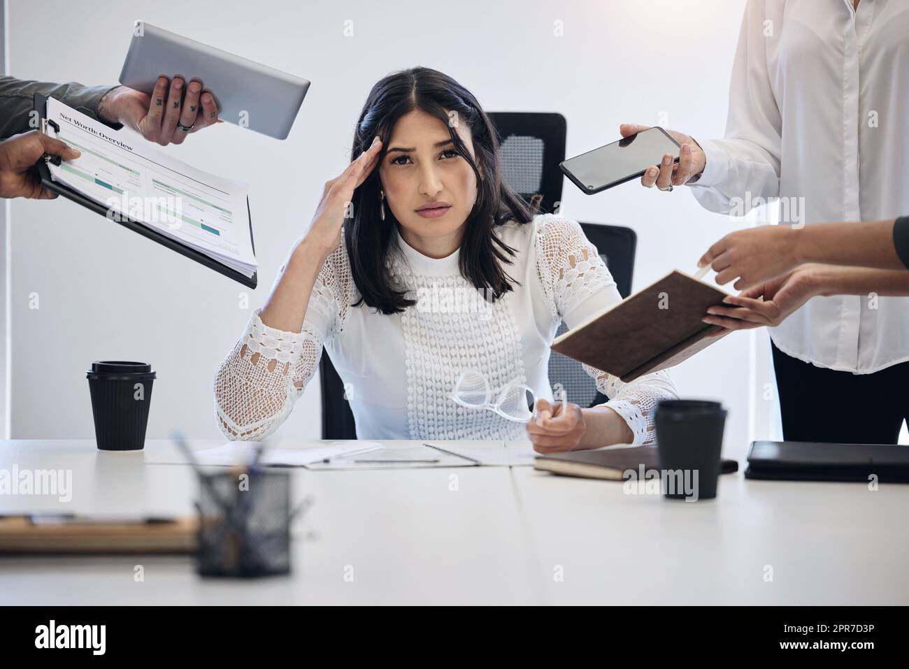 When can I leave. Shot of a young businesswoman looking stressed out in a demanding work environment. Stock Photo