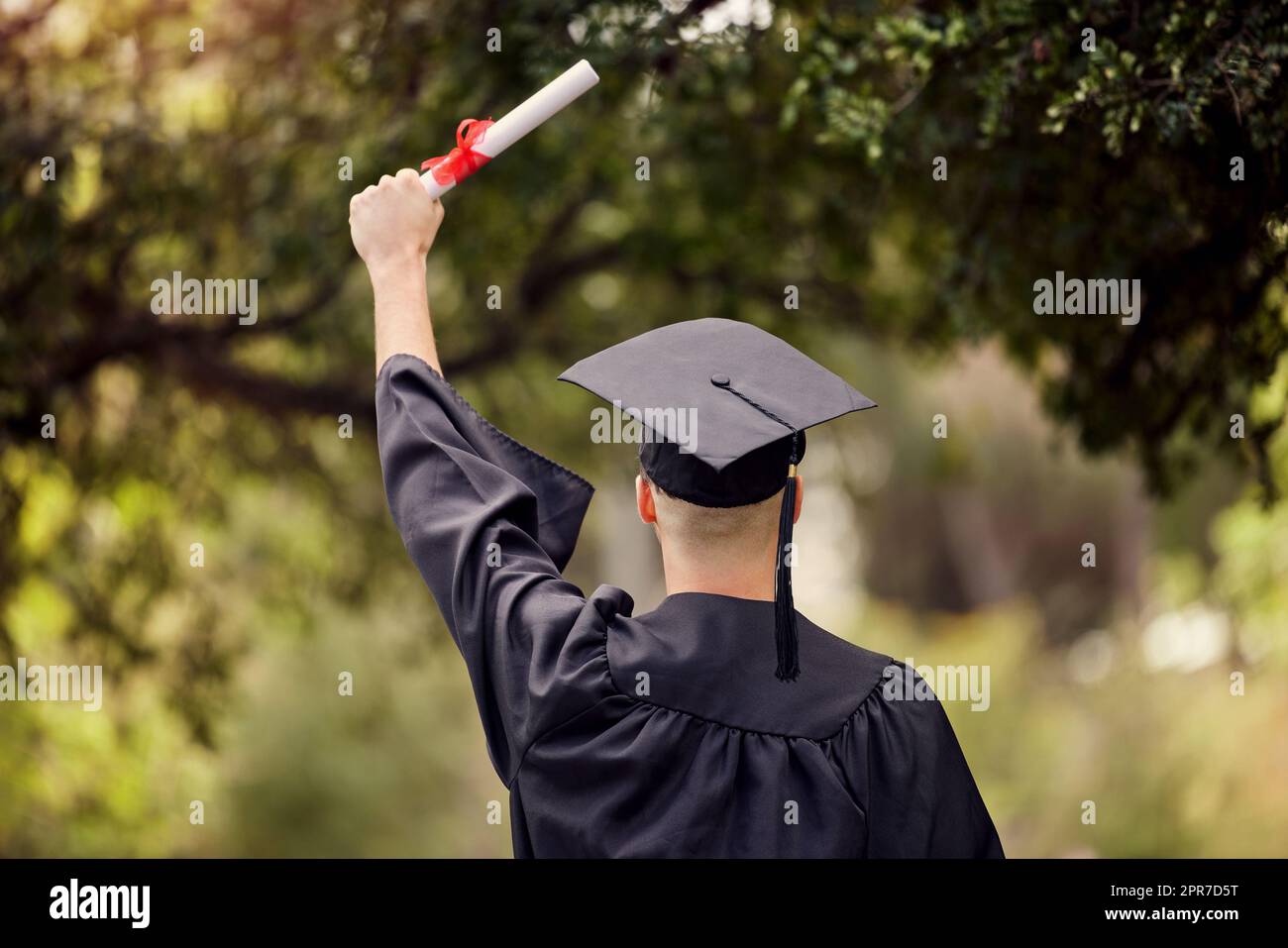 It can only get better from here on. Rearview shot of a young man cheering on graduation day. Stock Photo