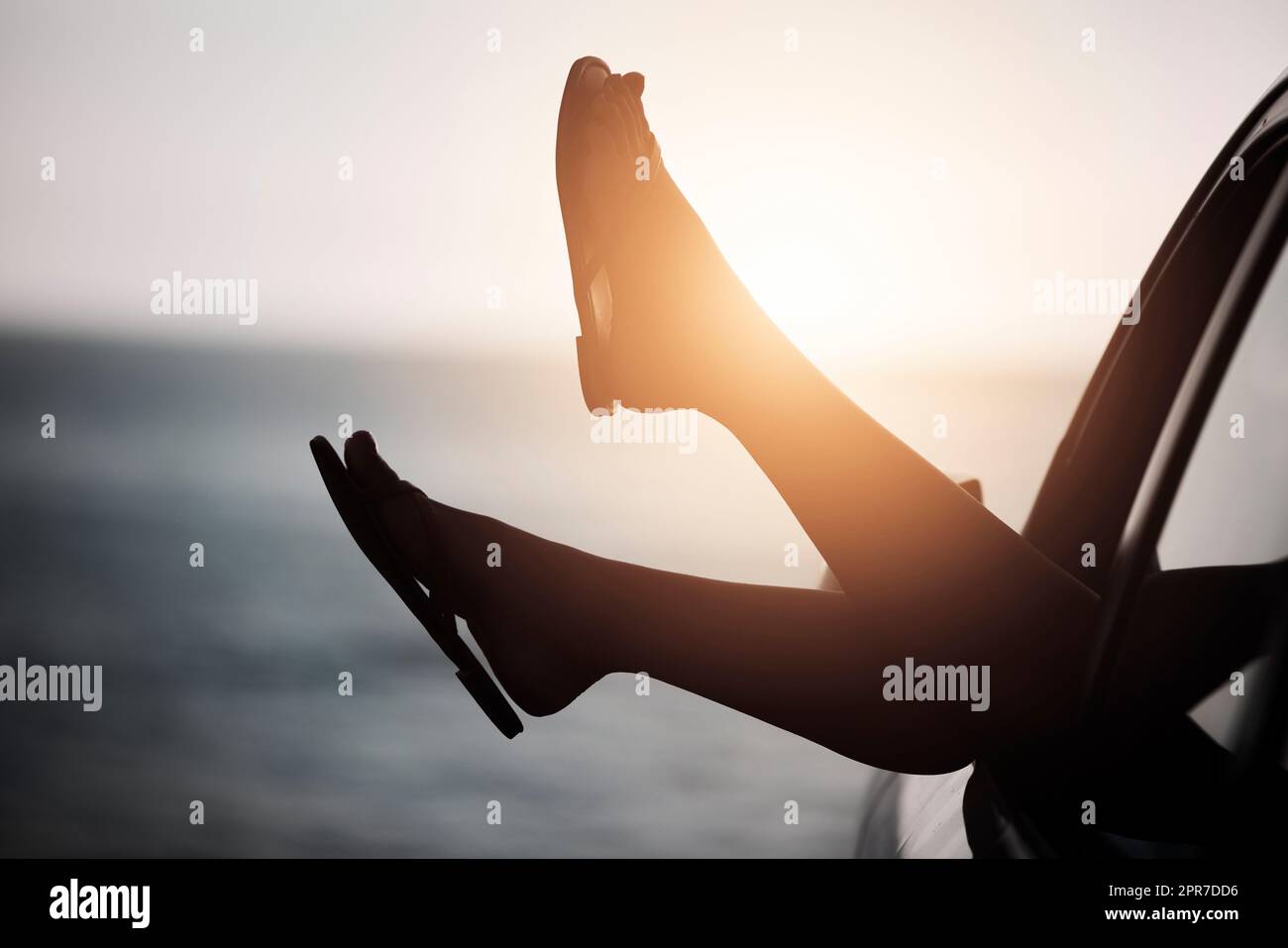 Kick your feet up and just relax. a womans feet hanging out the car