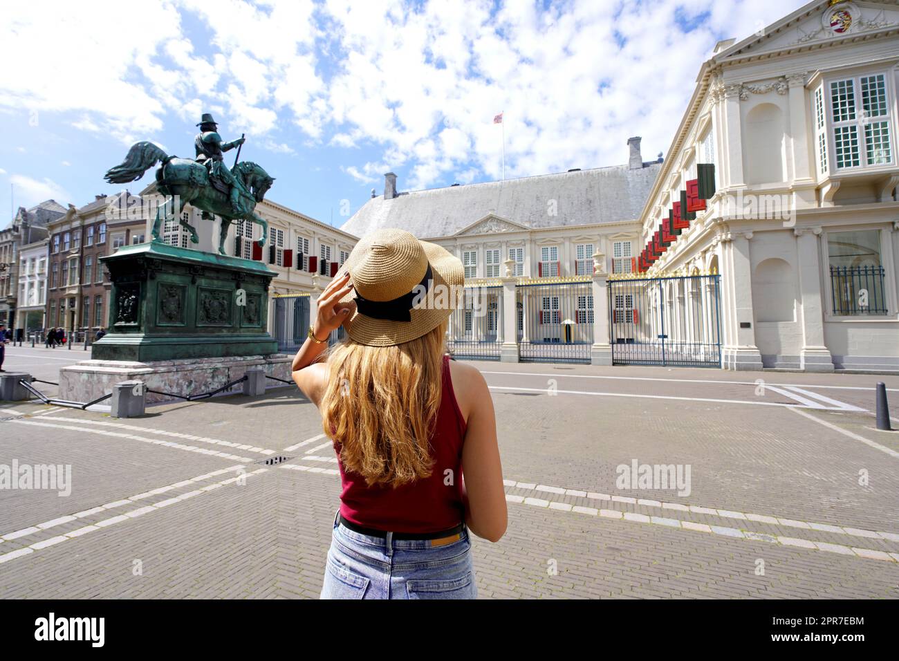 Tourism in Holland. Back view of young tourist woman visiting Noordeinde Palace in The Hague, Netherlands. Stock Photo