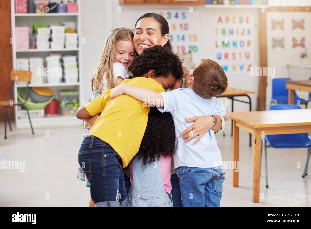 We love our teacher. Shot of a woman hugging her learners. Stock Photo