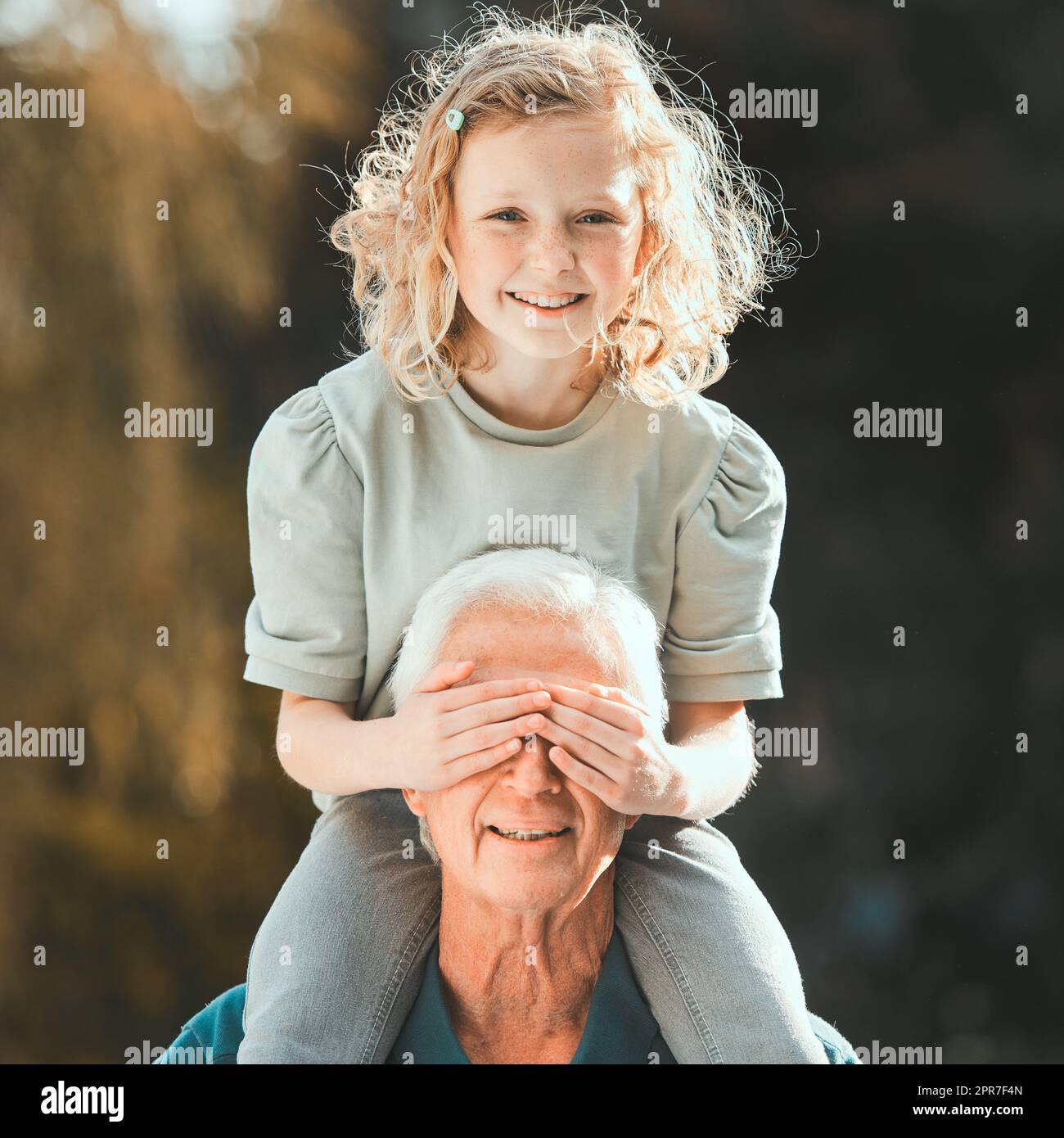 Little girls are the nicest things that happen to people. Shot of a girl being carried by her grandfather outside. Stock Photo