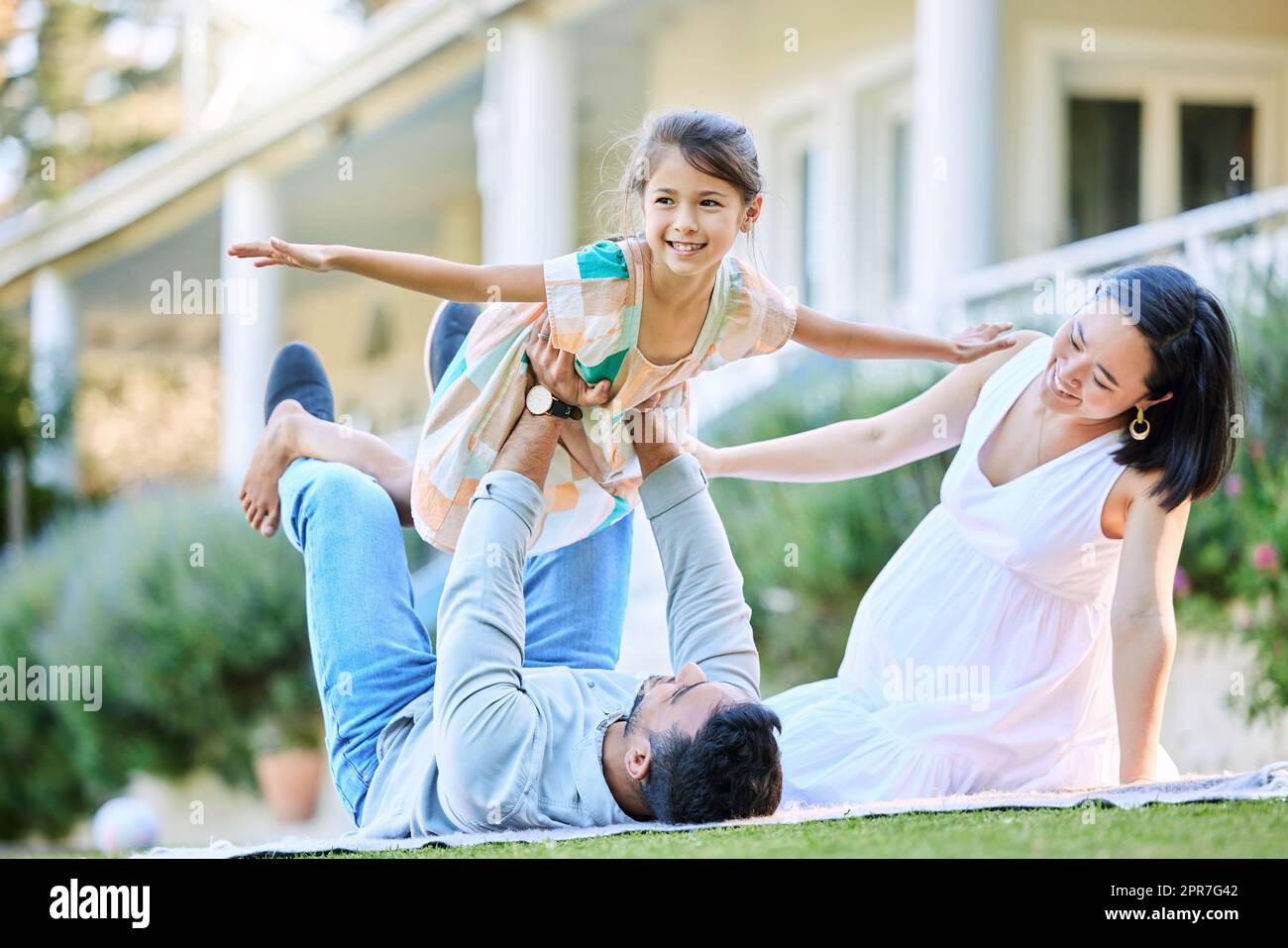 Be as free as you want to be. Shot of a young family relaxing in their garden outside. Stock Photo