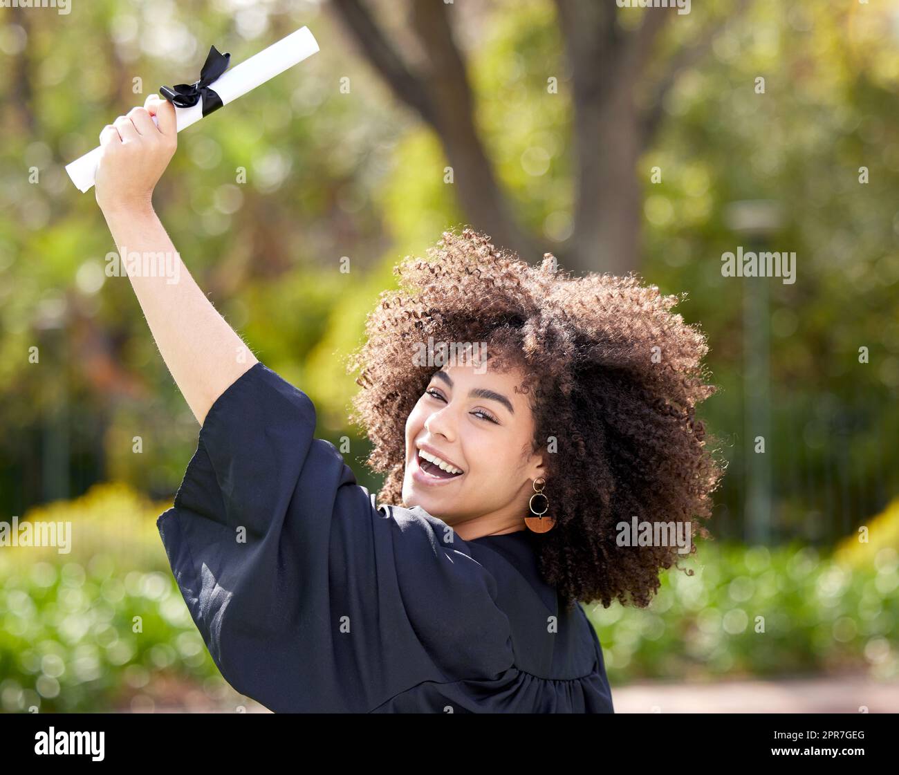 Go be amazing. Portrait of a young woman cheering on graduation day. Stock Photo