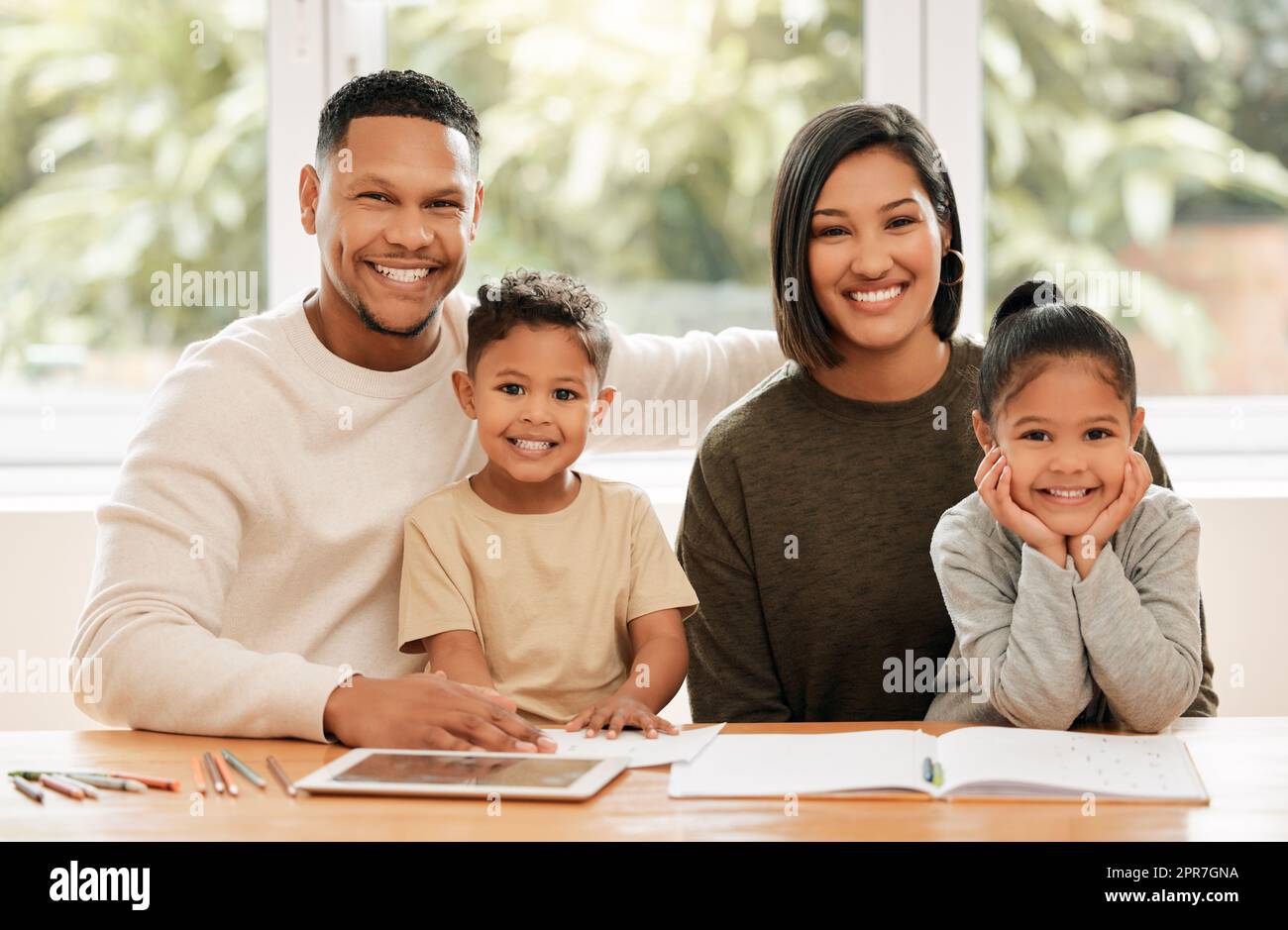 Learning together. Shot of a young family doing homework together at home. Stock Photo