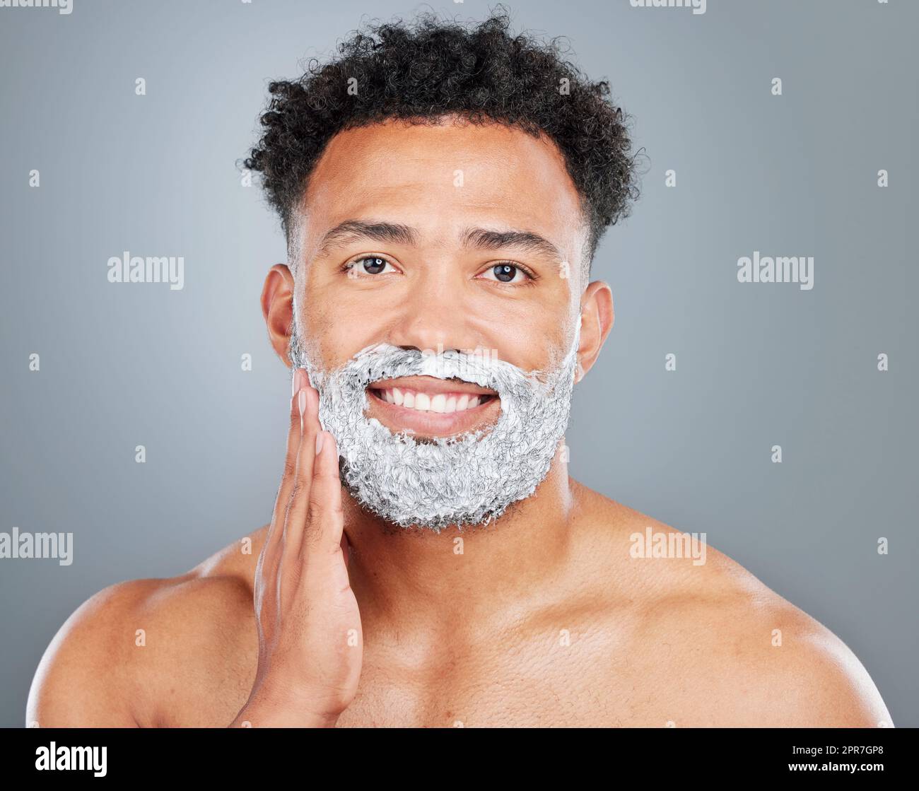I think its time to shave. Studio portrait of a handsome young man shaving against a grey background. Stock Photo