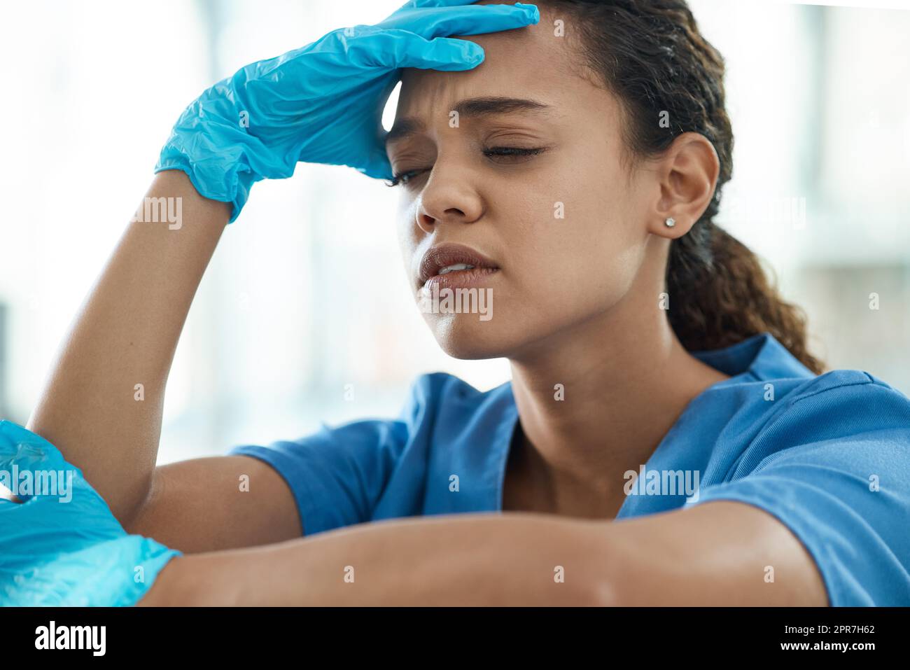 Be nice to nurses. a female nurse looking stressed while sitting in a