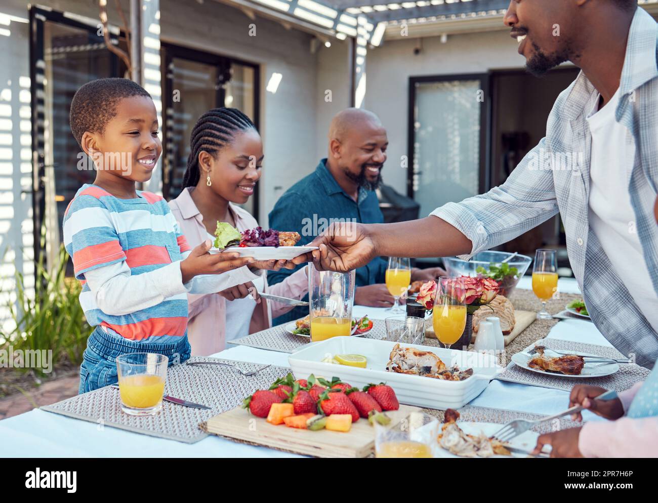 There you go. a happy family having lunch together outside in the garden. Stock Photo