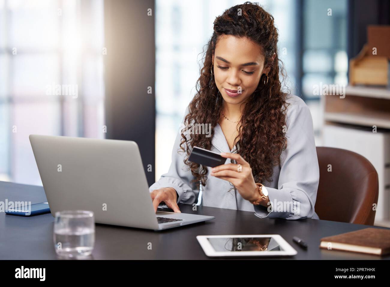 Cant wait for my package to arrive. a young businesswoman using her laptop to make online card payments. Stock Photo