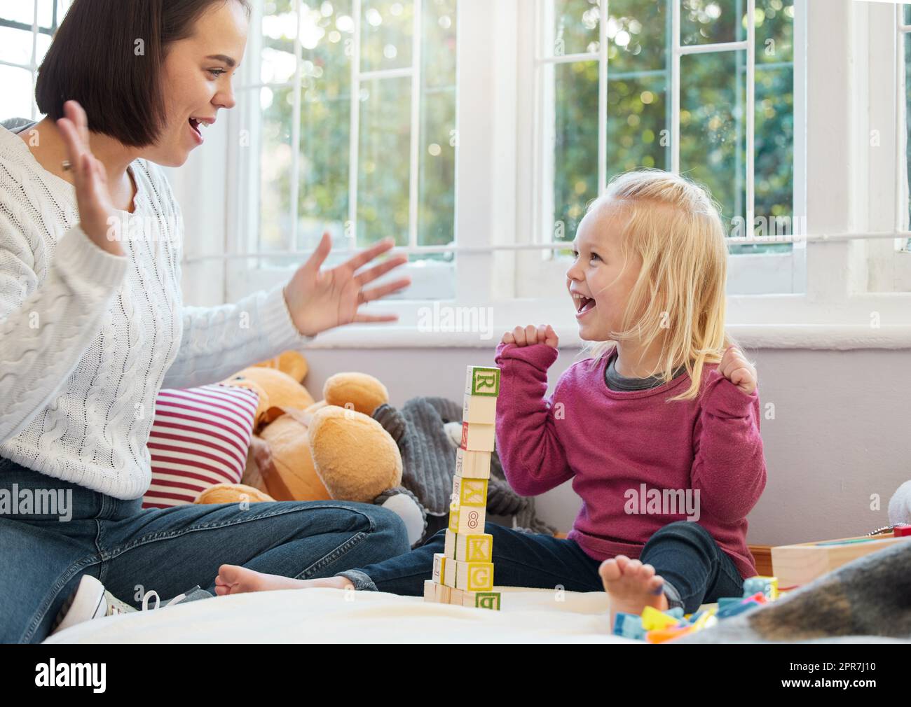 A little bit of cheering on can get you far. a little girl stacking blocks with her mother at home. Stock Photo