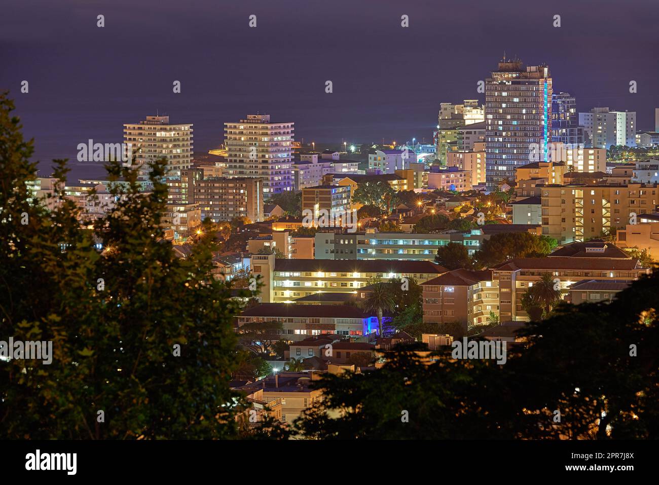 City lights of Cape Town at night from above with copy space. Panoramic coastal urban landscape at sunset. High angle view from Signal Hill, South Africa of the cityscape and a beautiful horizon Stock Photo