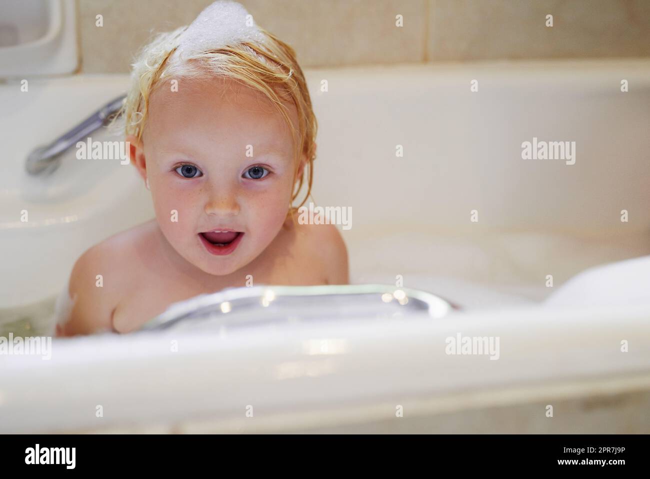 Bubble bath fun. Portrait of an adorable little girl having a bubble