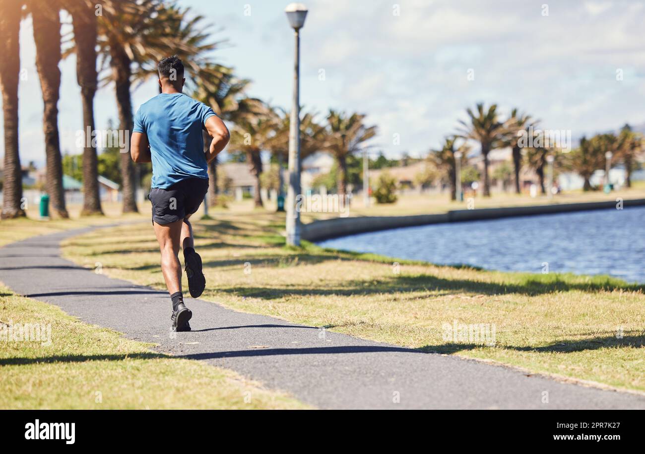 Back view of female jogger wearing running outfit standing on trail in wood  ready to run.