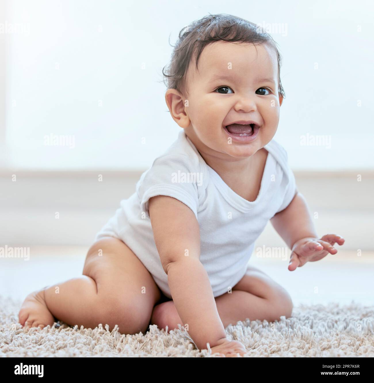 Shes up to no good. an adorable baby girl crawling on the floor at home. Stock Photo