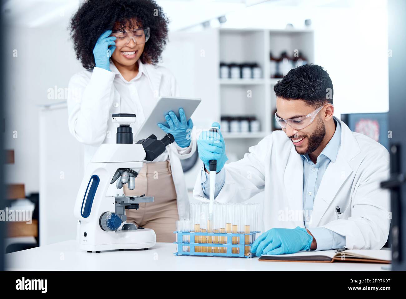 Two mixed race scientists wearing safety equipment while conducting