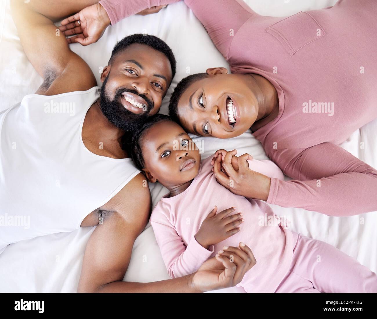Our task is to transform ourselves. a young family bonding in bed together. Stock Photo