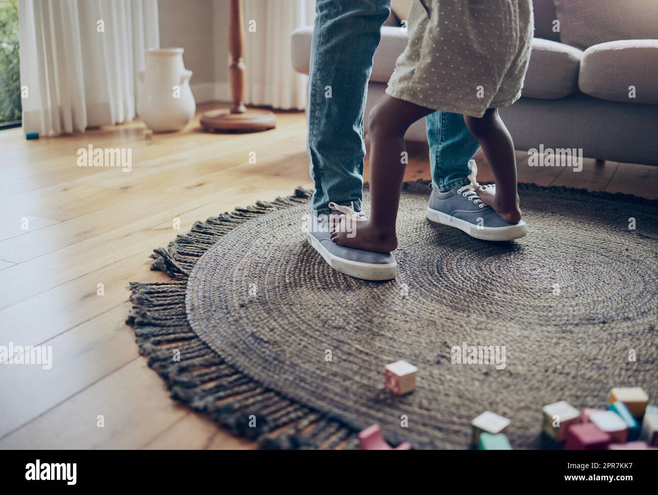 Lets dance. an unrecognizable parent and child dancing together at home. Stock Photo