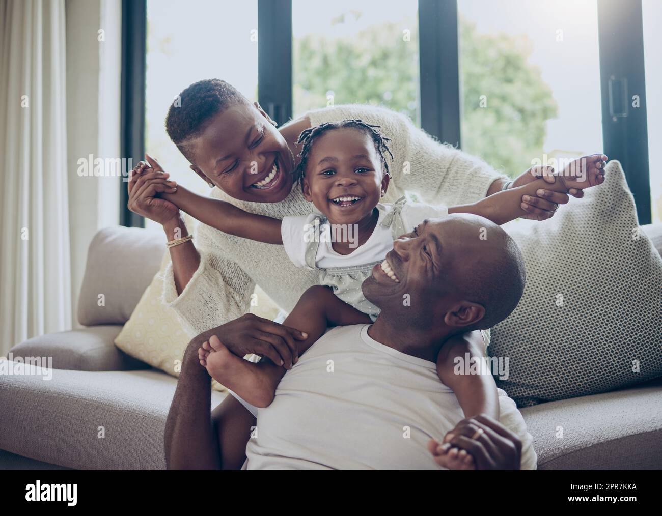 Happy daughter, happy parents. a young family spending time together at home. Stock Photo