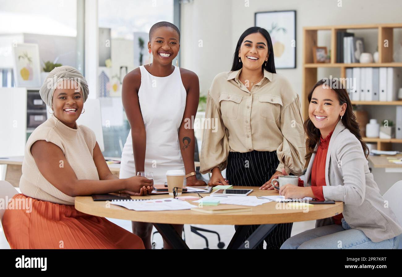 Portrait of diverse group of young ethnic business women having a brainstorm meeting in office. Ambitious confident professional team of colleagues talking and planning a marketing strategy together Stock Photo