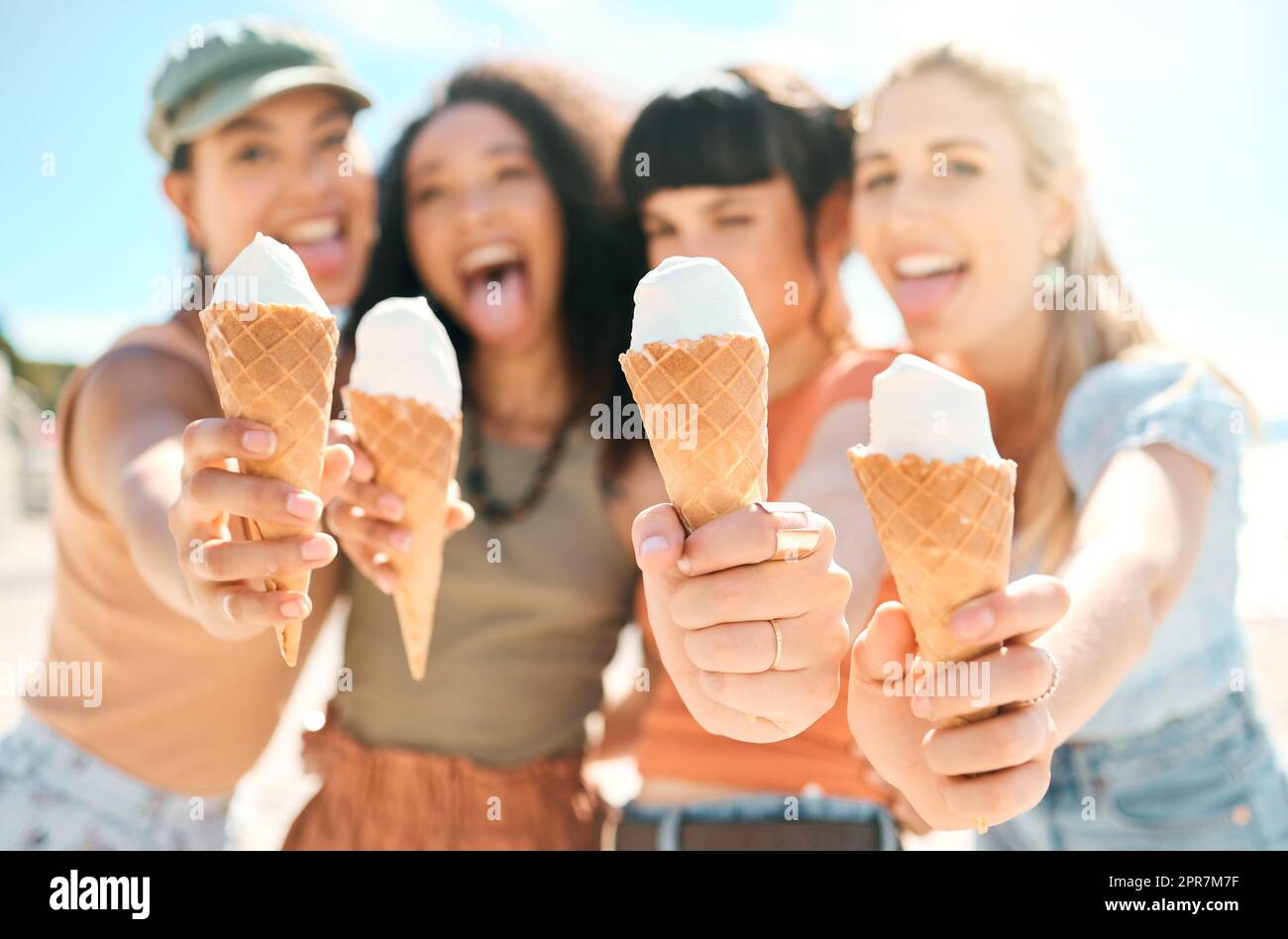 Premium Photo  Multiethnic friends in an ice cream parlor sitting eating  an ice cream summer showing off the ice creams