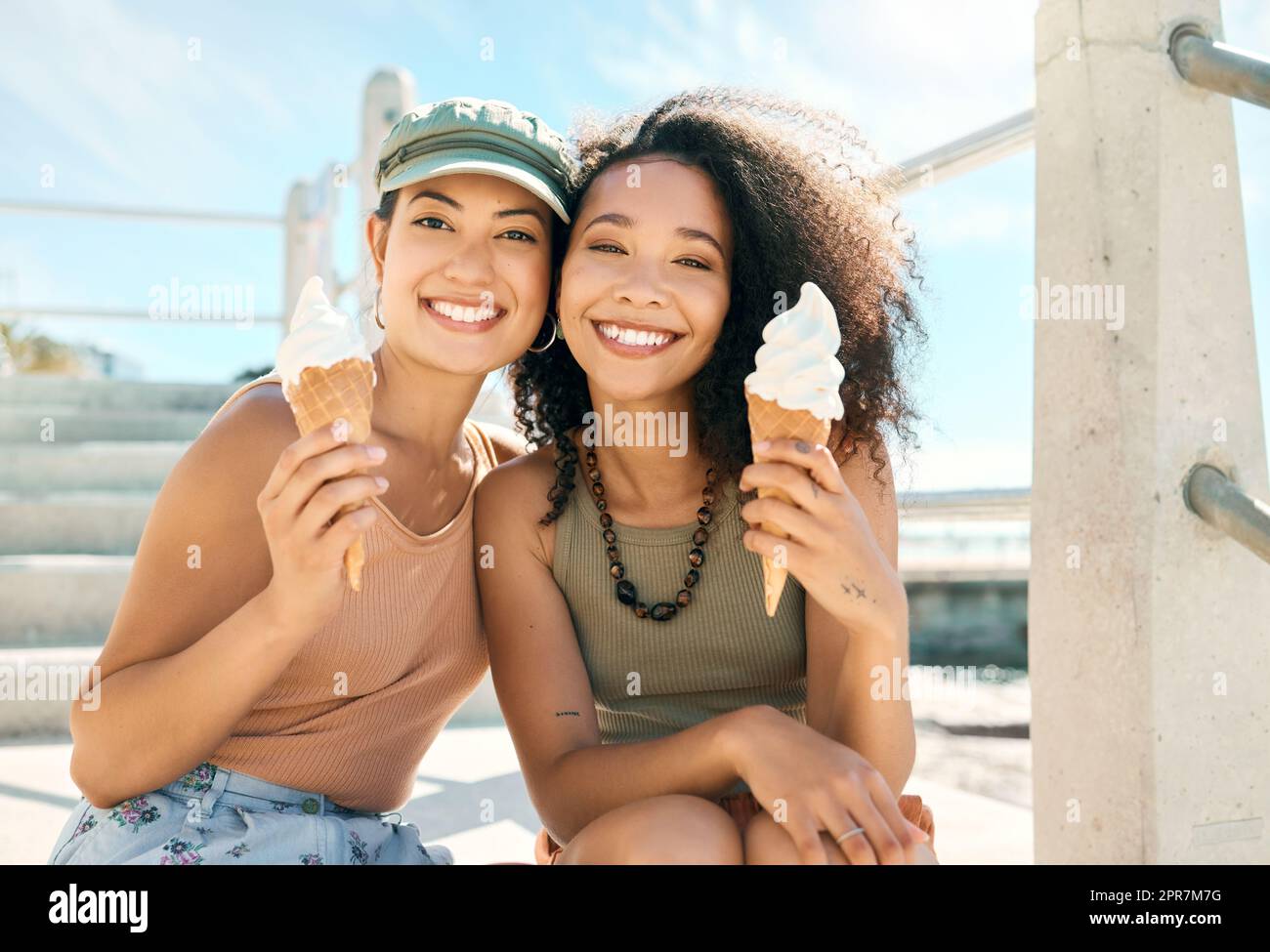 This is what summer is all about. Cropped portrait of two attractive young girlfriends enjoying ice creams on the beach. Stock Photo