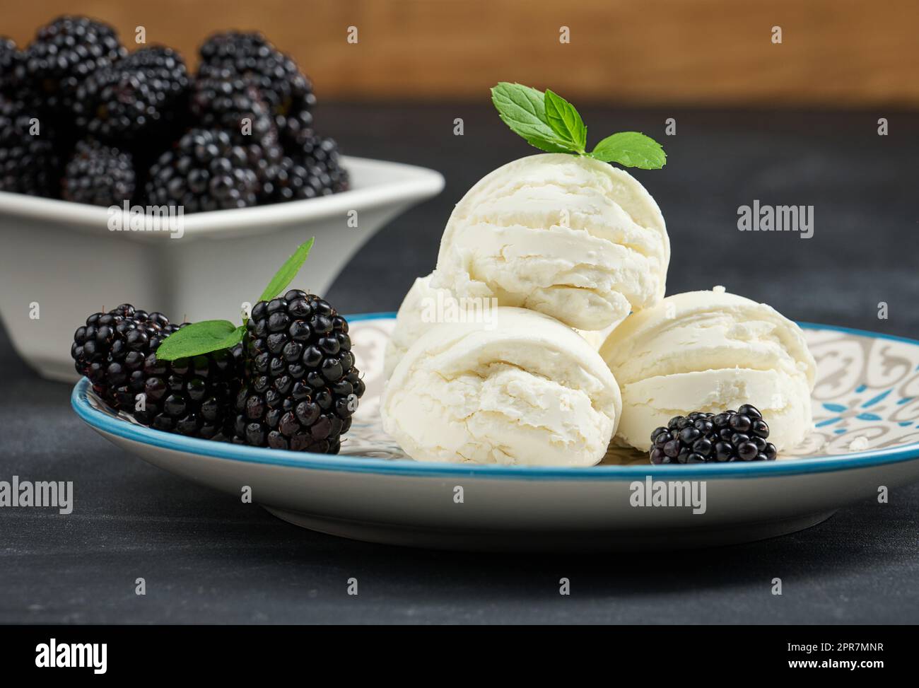 three flavored ice cream scoops on a pale blue plate, with