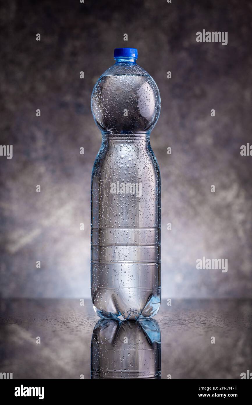 Plastic cold bottle of water with water drops. Stock Photo