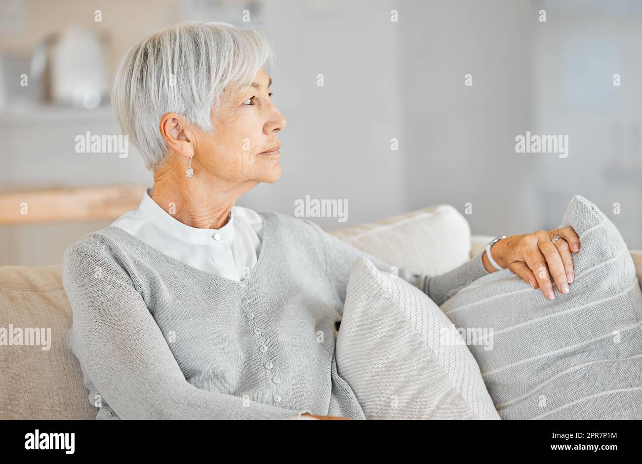The years have really just zoomed by.... Shot of a senior woman looking thoughtful at home. Stock Photo