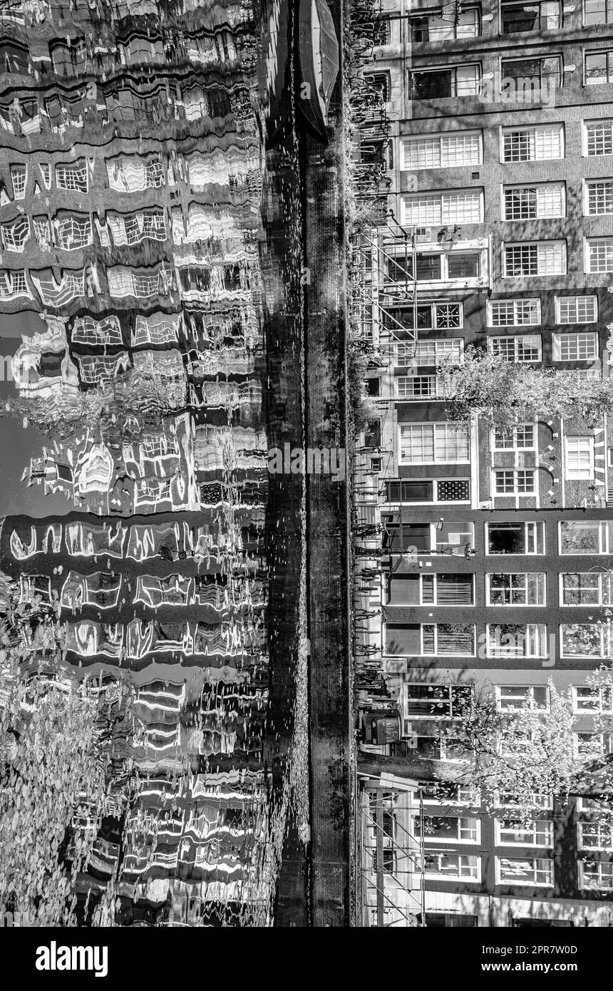 Reflection of the buildings along the canal in Amsterdam, the Netherlands. Black and white image Stock Photo