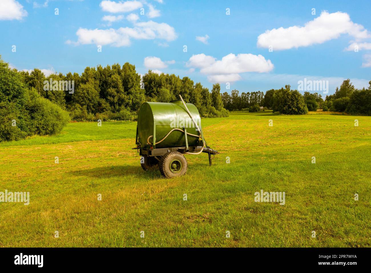 Mobile water tank for watering grazing cattle in a pasture Stock Photo