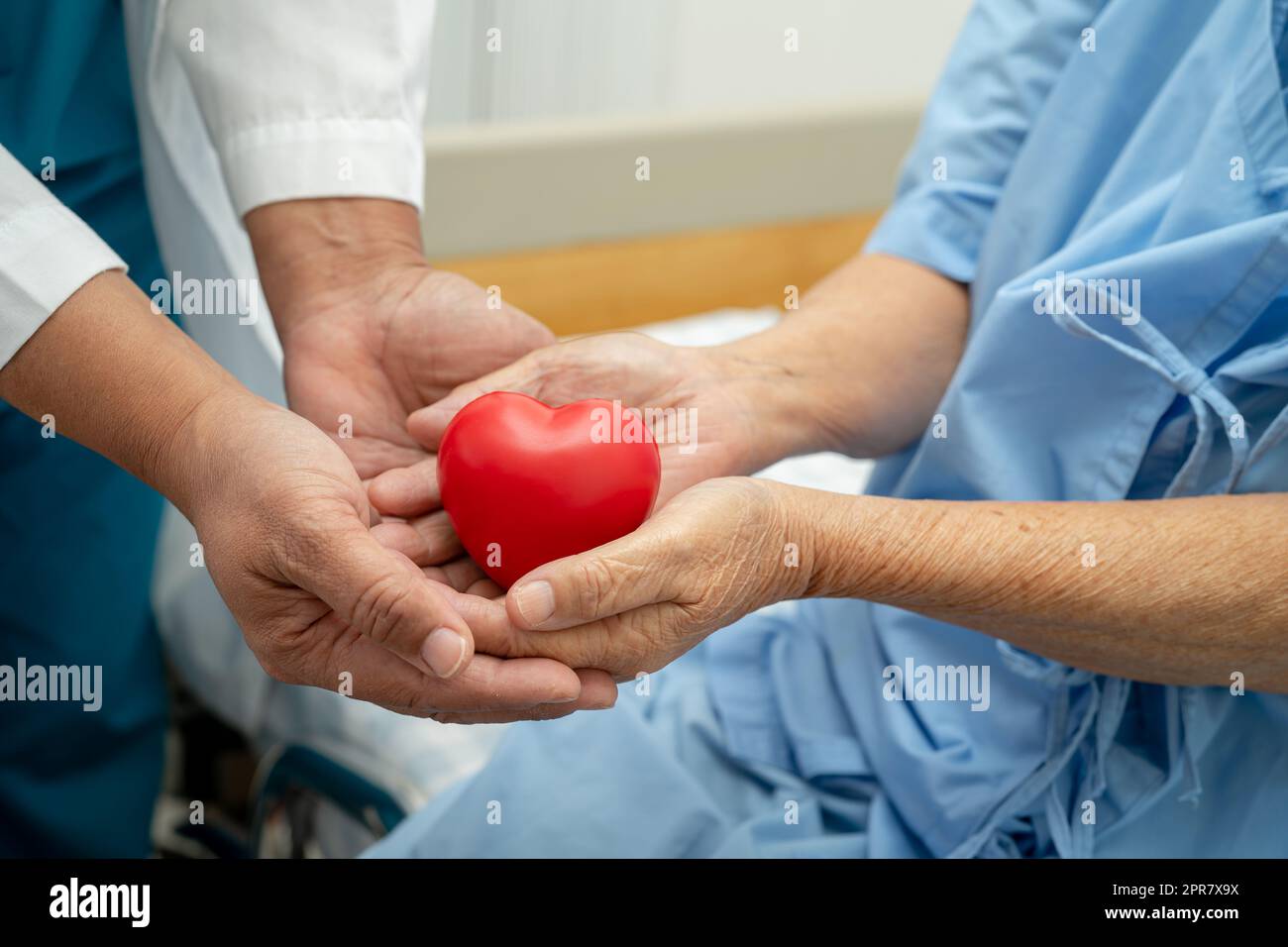 Doctor give red heart to Asian senior or elderly old lady woman patient, healthy strong medical concept Stock Photo