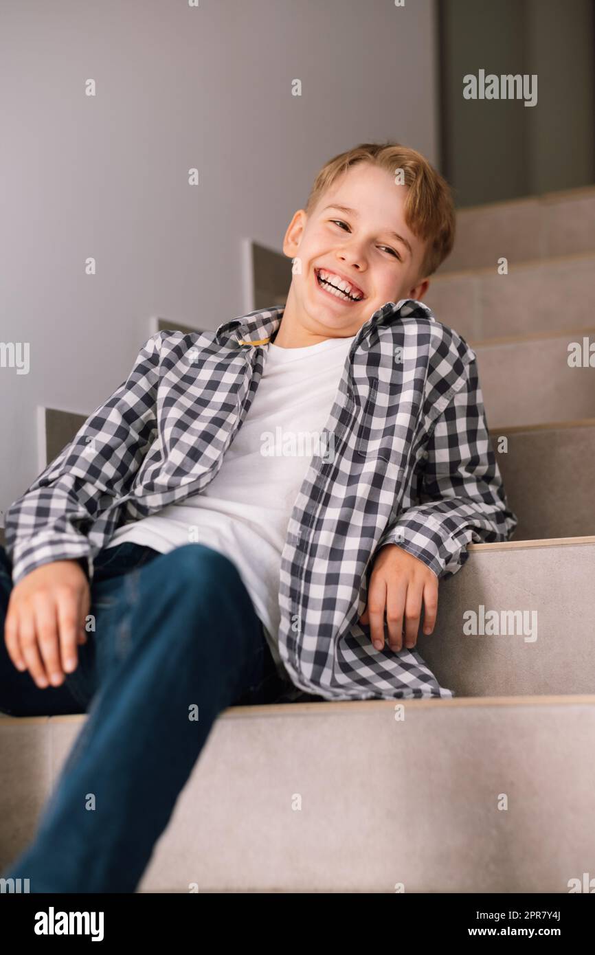 Portrait of a handsome young guy. Laughing young teenage man sitting on ...