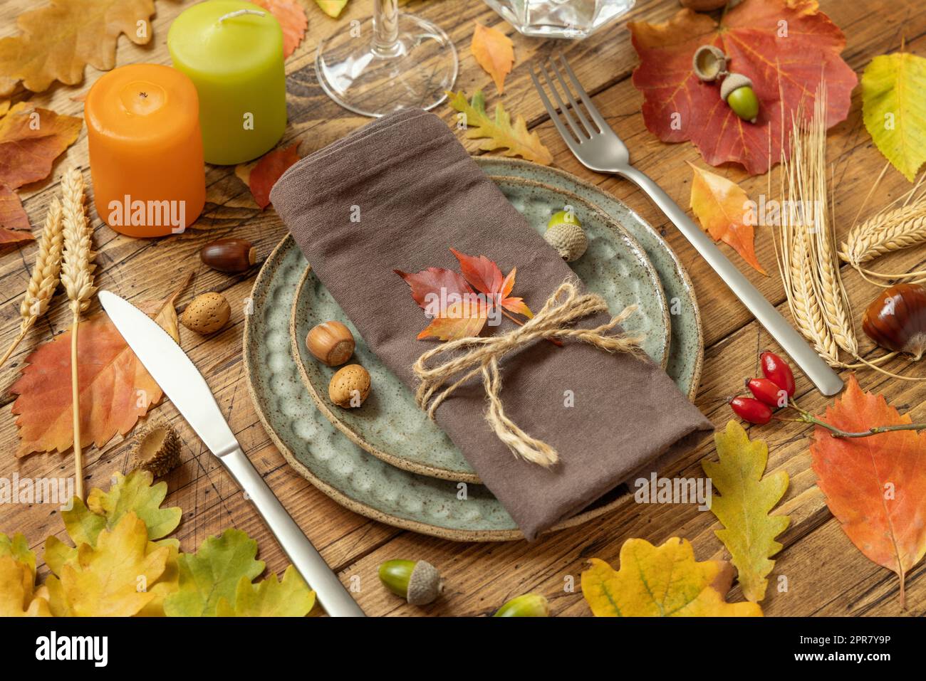 Autumn rustic table setting between leaves and berries on vintage wooden table close up Stock Photo