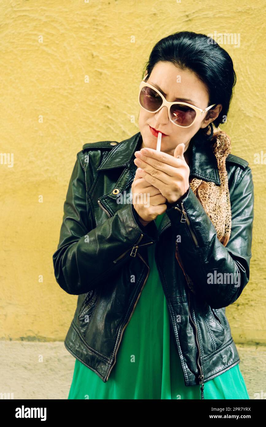 Modern young woman in fashion designer clothes smoking cigarette in