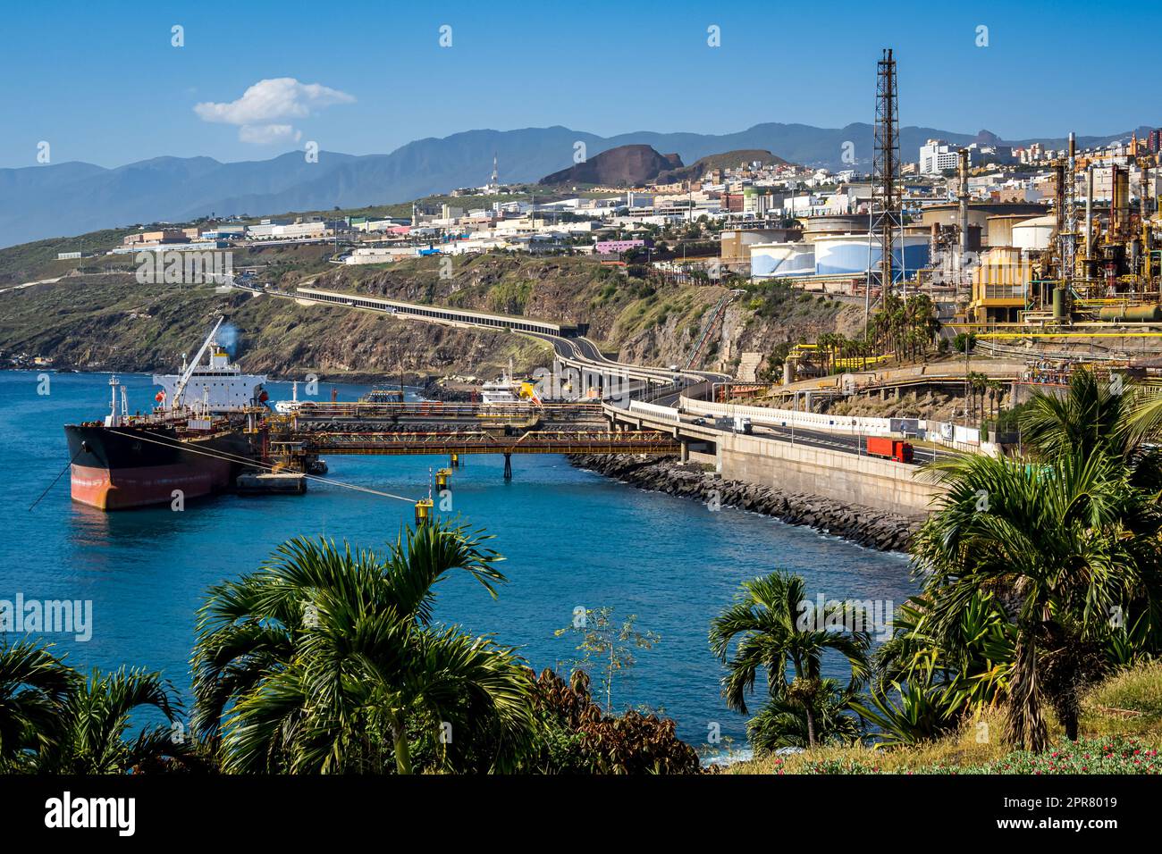 Santa Cruz de Tenerife with the oil refinery at Puerto de Honduras harbor, showcasing nature and the urban skyline with TF-4 highway and moored tanker Stock Photo