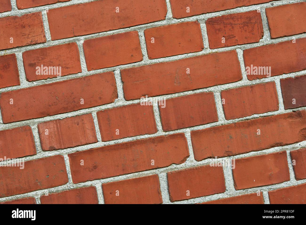 Closeup of a red brick wall with copy space. Detail of recently built exterior masonry or historic design wall background patterns and textures. Outside zoom of modern industrial style architecture Stock Photo