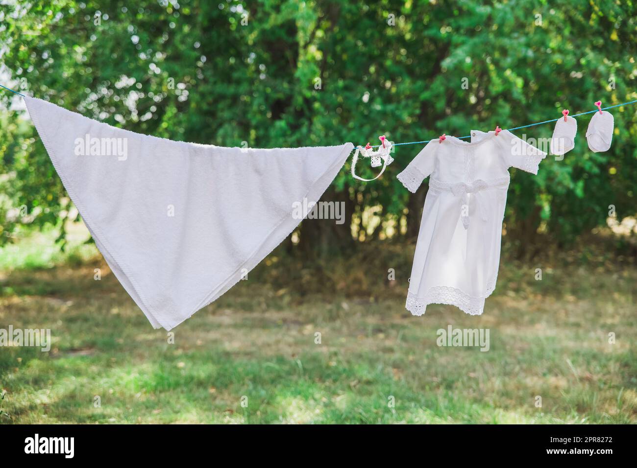 baby clothes hanging in the garden on a clothesline Stock Photo Alamy