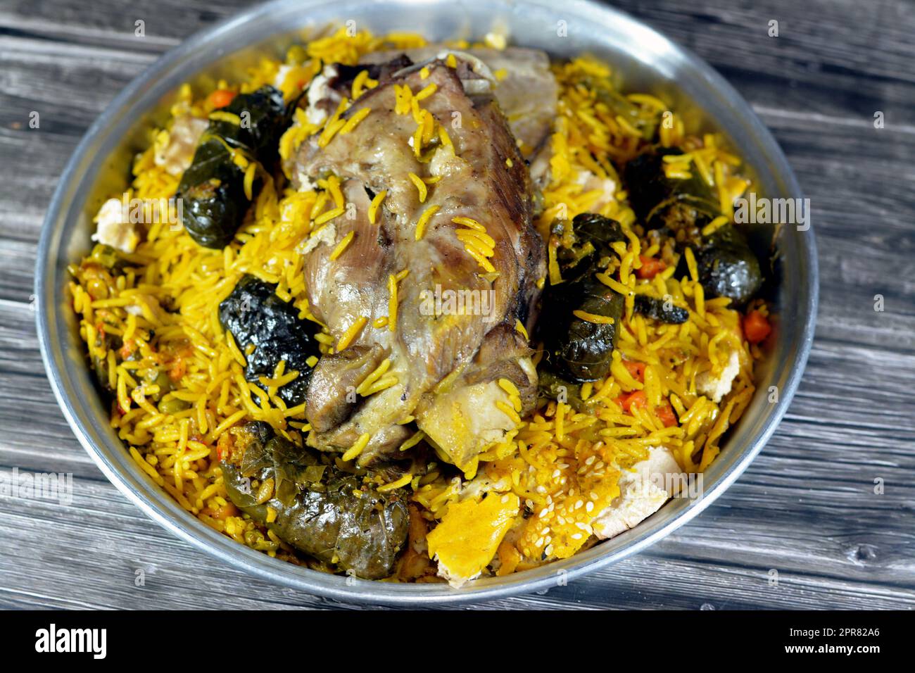 A well cooked lamb shank with yellow Basmati rice and mixed vegetables