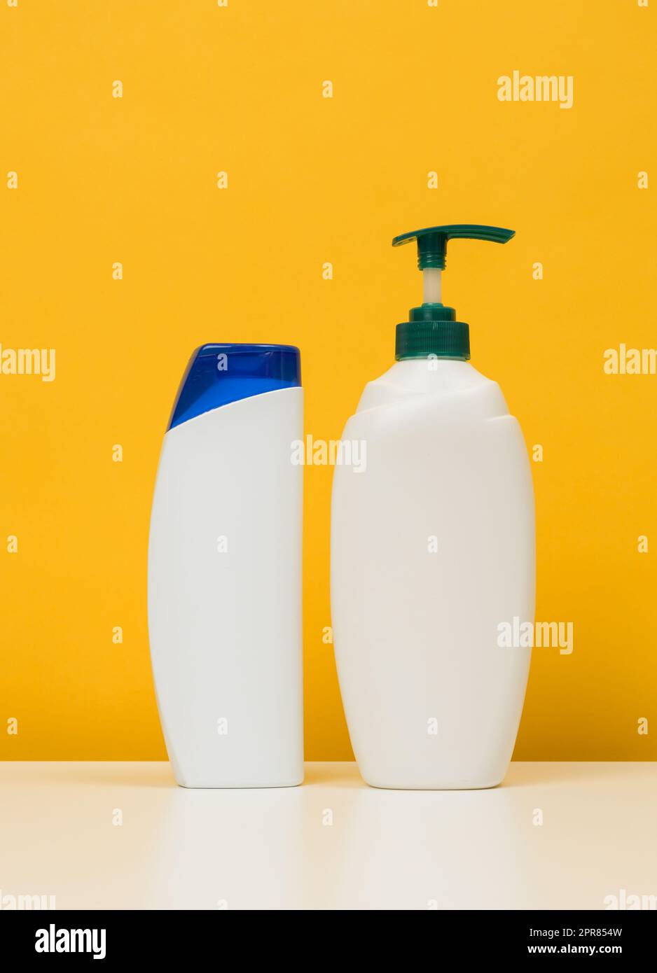 Plastic bottles with a pump for shampoo, shower gel on a white table