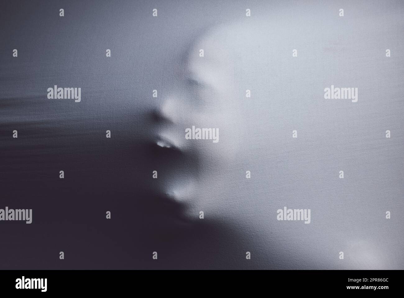 Everybody knows there is no such thing as normal. Shot of a scary figure confined under a sheet. Stock Photo