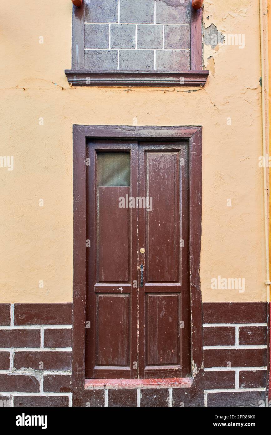 Old house or church with peeling paint on wall or window and wooden shutter door. Vintage and aged residential building built in a traditional architectural style or design in Santa Cruz de La Palma Stock Photo