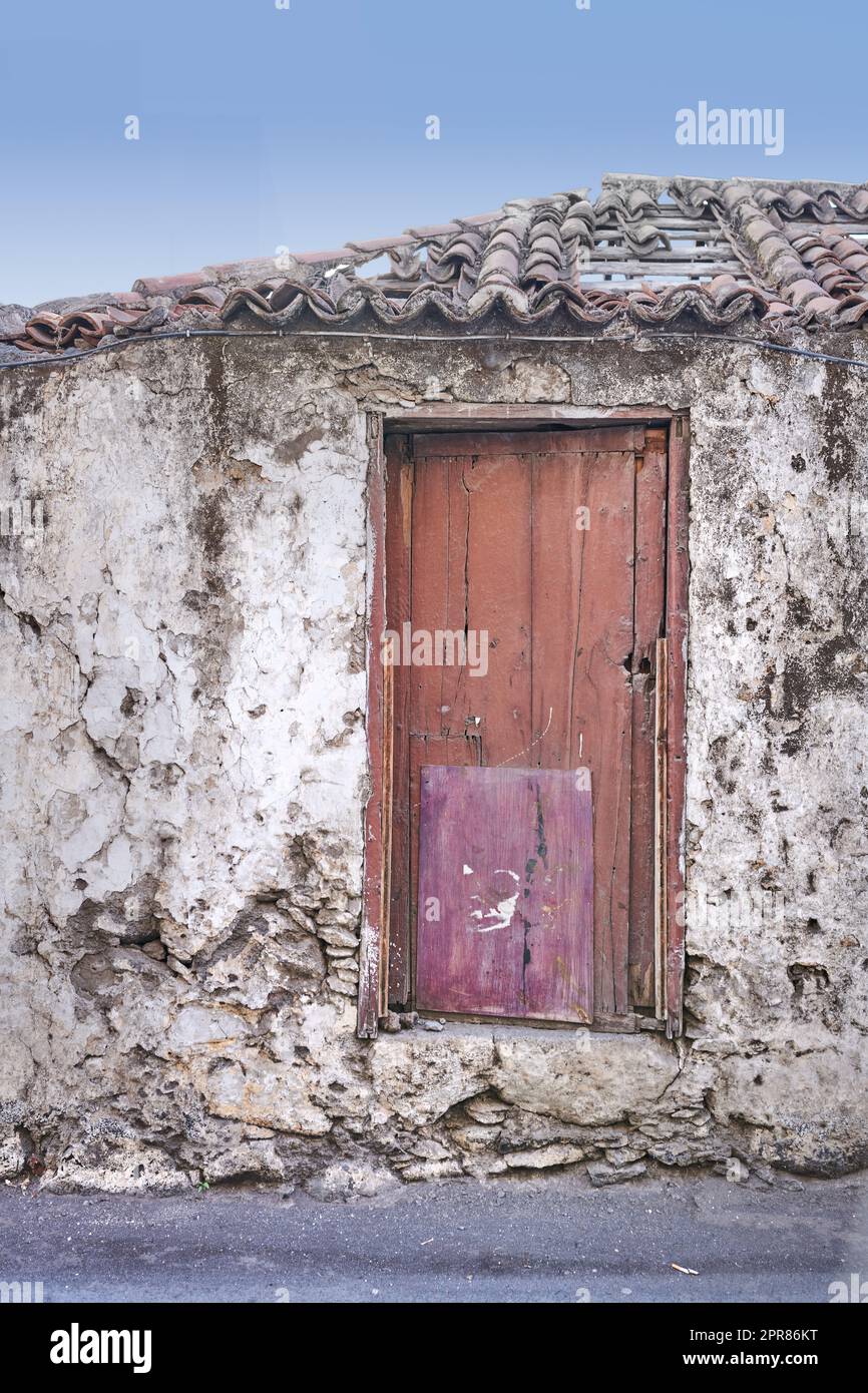 Old abandoned house or home with a weathered stone wall and red wooden ...