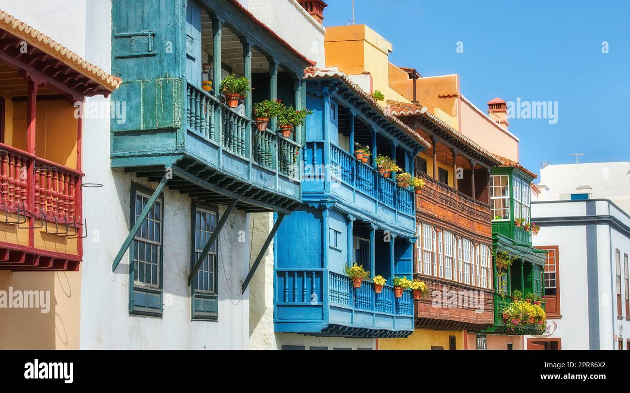 Old buildings in a city built by traditional architecture in a small town or village. Home or flats with a vintage design close to each other outdoors with a blue sky in Santa Cruz de La Palma Stock Photo